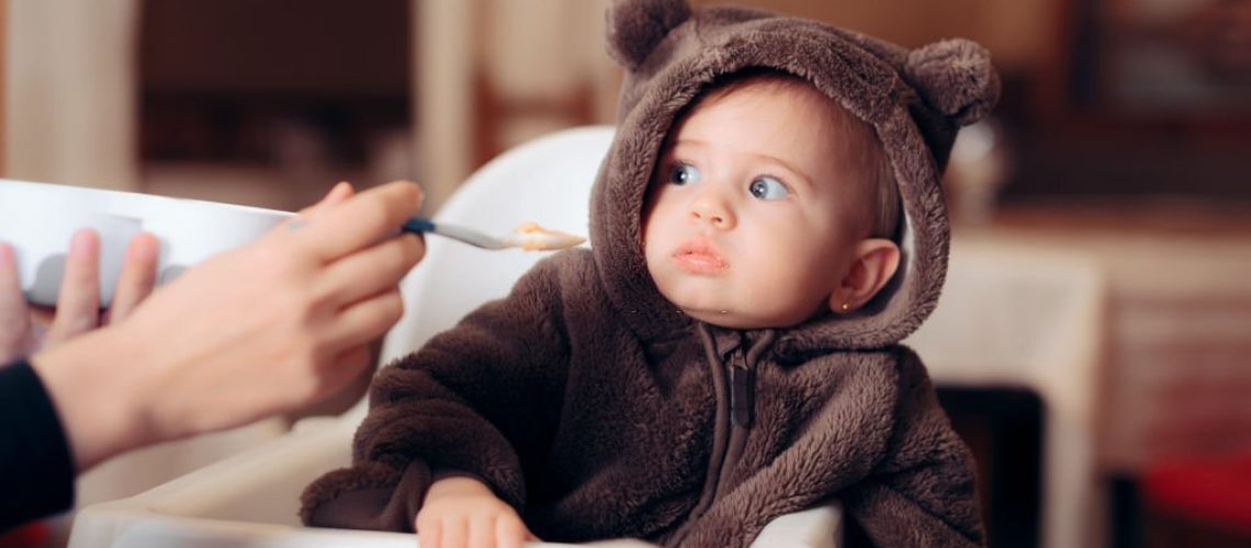 Small infant being a picky eater disliking the food