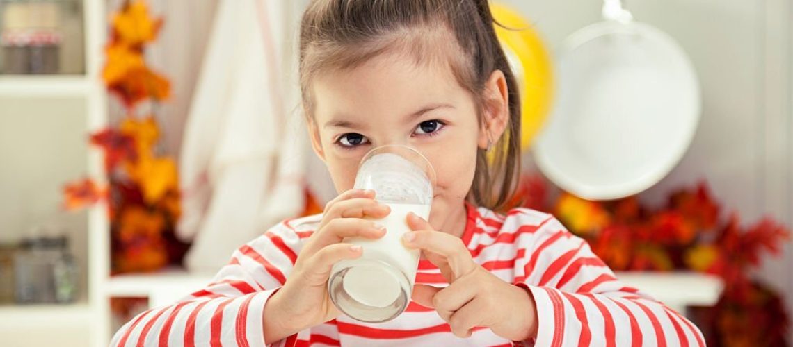 Beautiful Little Girl Drinking Glass of Milk