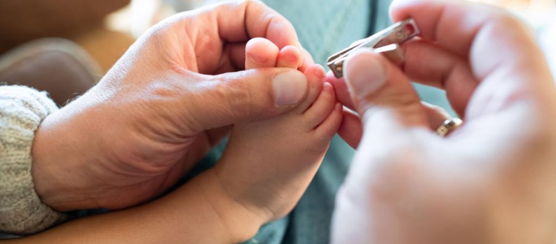 Parent cutting nails to his child